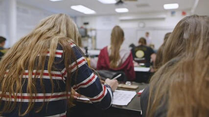 Students writing during a classroom learning session