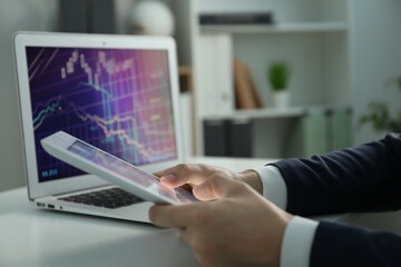 Businesswoman using tablet at white table indoors, closeup. Modern technology