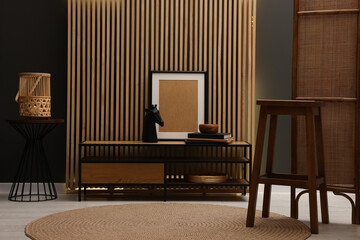 Bar stool, wooden cabinet and decor elements in room. Stylish interior design