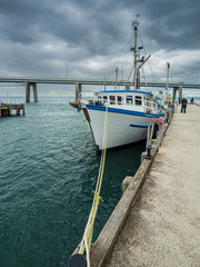 Fototapeta premium View Along Rope To Trawler Before Bridge vert