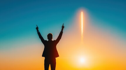 Fototapeta premium Silhouette of a businessman celebrating a rocket launch at sunset.