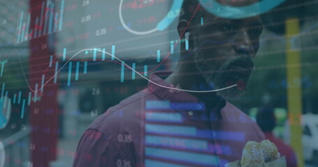Image of financial data processing over african american man eating sandwich in city