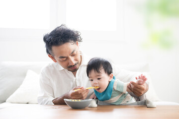 離乳食を食べさせるパパ