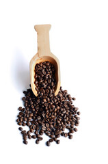 Fresh coffee beans in a wooden spoon.