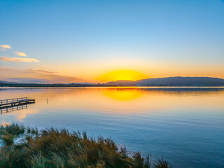 Sunrise along the waterfront with reflections on the bay water