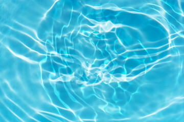 Blue water with ripples on the surface. Defocus blurred transparent blue colored clear calm water surface texture with splashes and bubbles. Water waves with shining pattern texture background.