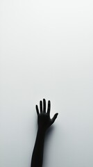 A monochrome image featuring a black hand reaching upwards against a minimalistic white background, symbolizing hope and longing.