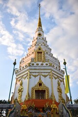 Fototapeta premium A stunning pagoda adorned with intricate golden details, rising against a backdrop of fluffy clouds, capturing the essence of traditional architecture.