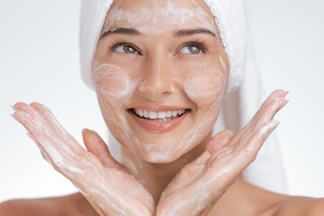 Smiling Woman Washing Face with Foaming Cleanser in Skincare Routine
