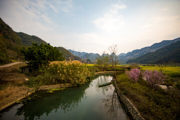 Fototapeta premium An ancient village called Bamei in eastern Yunnan, China, with rapeseed flowers and terraced fields