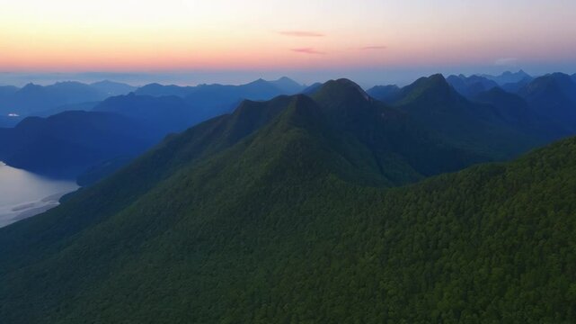 Flying over the beautiful panorama of mountain ranges at dusk.