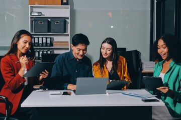 Young corporate employees sitting in office looking at laptop screen reading good news excited happy team diverse people celebrating victory win command success excellent result professional teamwork