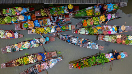 Fototapeta premium Aerial view Damnoen Saduak floating market, Farmer go to sell organic product, fruit, vegetable and Thai cuisine, Tourist visiting by boat, Ratchaburi, Thailand, Famous floating market in Thailand.