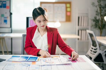 Focused asian professional creating optimal user experience for mobile app, designing user...