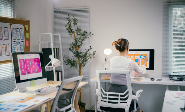 Young ux ui designer is working on a new mobile application, using sticky notes to plan the layout and design of the user interface