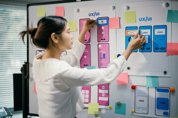 Female ux ui designer is arranging a wireframe application layout development template for a mobile...