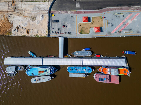 Aerial drone view showcasing boats lined along the pier on the waterfront in a small city in the brazilian Amazon region