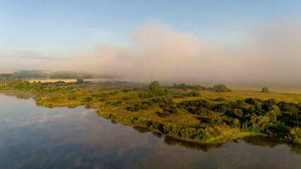 Fog rises from the lake at dawn