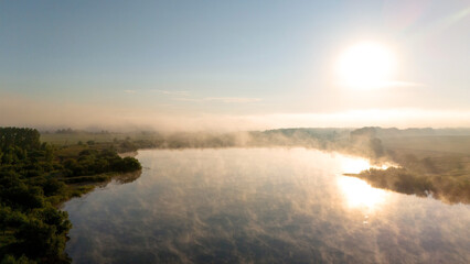 Fog rises from the lake at dawn