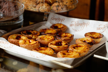 Fresh baked Pastel de nata or Pastel de belém .The most famous sweet in Portugal. Tart on baking sheet/