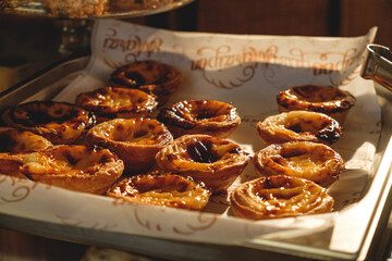 Fresh baked Pastel de nata or Pastel de belém .The most famous sweet in Portugal. Tart on baking sheet/