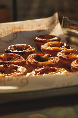 Fresh baked Pastel de nata or Pastel de belém .The most famous sweet in Portugal. Tart on baking sheet/
