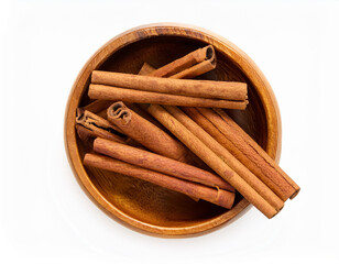 cinnamon sticks in wooden bowl, top view, flat lay, isolated white background