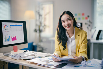Focused asian businesswoman analyzing data on laptop in modern office, showcasing entrepreneurial...