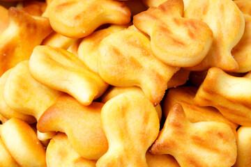 A collection of savory, bite-sized biscuits shaped like cute fish silhouettes, perfect as a snack. Photographed against a white background.