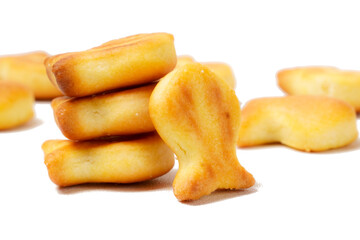 A collection of savory, bite-sized biscuits shaped like cute fish silhouettes, perfect as a snack. Photographed against a white background.