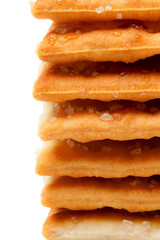 A stack of sweet crispy cracker sprinkled with sugar on top, set against a clean white background. The golden brown crackers create a simple yet appetizing display