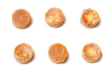 A neatly arranged of traditional brown sugar (gula jawa) cylindrical blocks isolated on a clean white background. The rich, caramel color contrasts beautifully with the crisp, minimalist backdrop