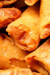 A bowl of Sumpia, Indonesian traditional mini spring rolls filled with shrimp floss. The crunchy outer wrapper is deep-fried to perfection. Photographed on a white background.