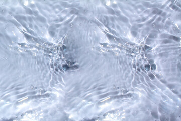 Obraz premium Bluewater waves on the surface ripples blurred. Defocus blurred transparent blue colored clear calm water surface texture with splash and bubbles. Water waves with shining pattern texture background.