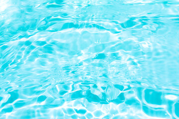 Obraz premium Blue water with ripples on the surface. Defocus blurred transparent blue colored clear calm water surface texture with splashes and bubbles. Water waves with shining pattern texture background.