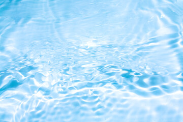 Obraz premium Blue water with ripples on the surface. Defocus blurred transparent blue colored clear calm water surface texture with splashes and bubbles. Water waves with shining pattern texture background.