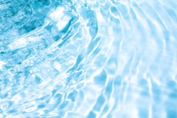 Obraz premium Blue water with ripples on the surface. Defocus blurred transparent blue colored clear calm water surface texture with splashes and bubbles. Water waves with shining pattern texture background.