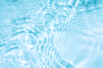 Blue water with ripples on the surface. Defocus blurred transparent blue colored clear calm water surface texture with splashes and bubbles. Water waves with shining pattern texture background.