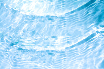 Obraz premium Blue water with ripples on the surface. Defocus blurred transparent blue colored clear calm water surface texture with splashes and bubbles. Water waves with shining pattern texture background.
