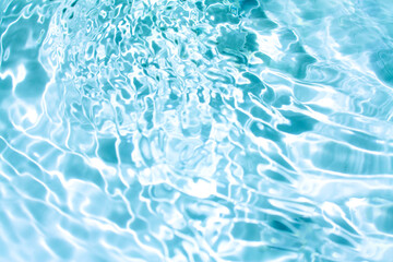 Obraz premium Blue water with ripples on the surface. Defocus blurred transparent blue colored clear calm water surface texture with splashes and bubbles. Water waves with shining pattern texture background.