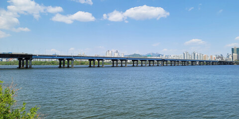 panorama view of the river, Yeouido Hangang River Park, in Seoul, Korea, with a broad bridge, and a cityscape in the backdrop	
