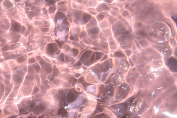 Pink water bubbles on the surface ripples. Defocus blurred transparent pink colored clear calm...
