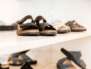 Leather sandals, black, elegant, comfortable, displayed on a modern shelf in a stylish footwear...