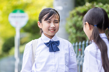 バス停で友達とお話しする学生