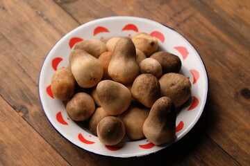 Volvariella volvacea is a species of edible mushroom cultivated throughout East and Southeast Asia and used extensively in Asian cuisines. straw mushroom in wooden box. jamur merang. 