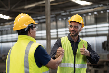 Two male engineer join hands together in industry factory. Finished, completed work concept