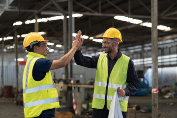 Two male engineer join hands together in industry factory. Finished, completed work concept