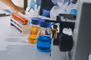 Scientist using microscope in laboratory. Close-up of a researcher's hands adjusting a modern...