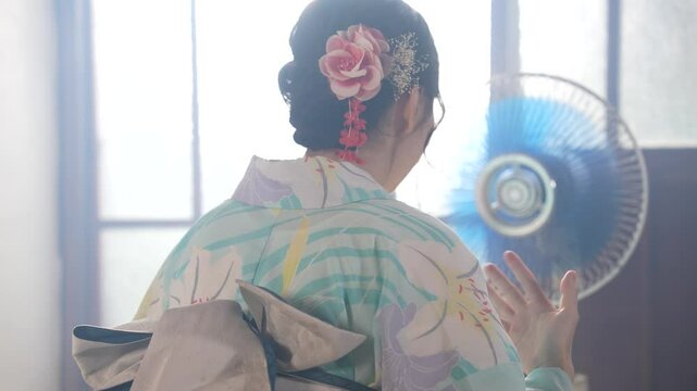 京都の古民家で浴衣を着た女性が扇風機で涼んでいる