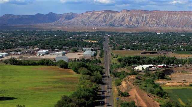 Summer Grand Mesa downtown Main Street Grand Junction Colorado river aerial drone forward pan up motion afternoon cloudy blue sky wine vineyards Parachute Fruitvale Mt Garfield Western Close Delta USA